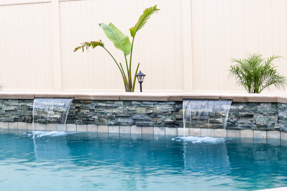 На фото: бассейн среднего размера, произвольной формы на заднем дворе в классическом стиле с покрытием из бетонных плит