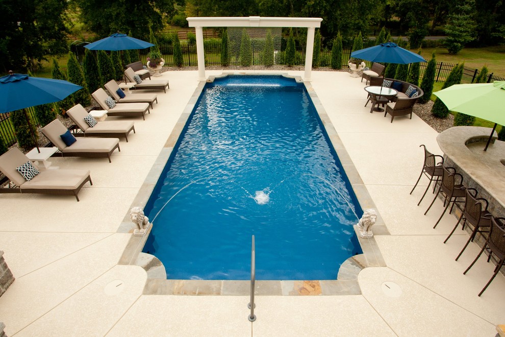 Example of a large tuscan courtyard rectangular aboveground pool design in Nashville with decking