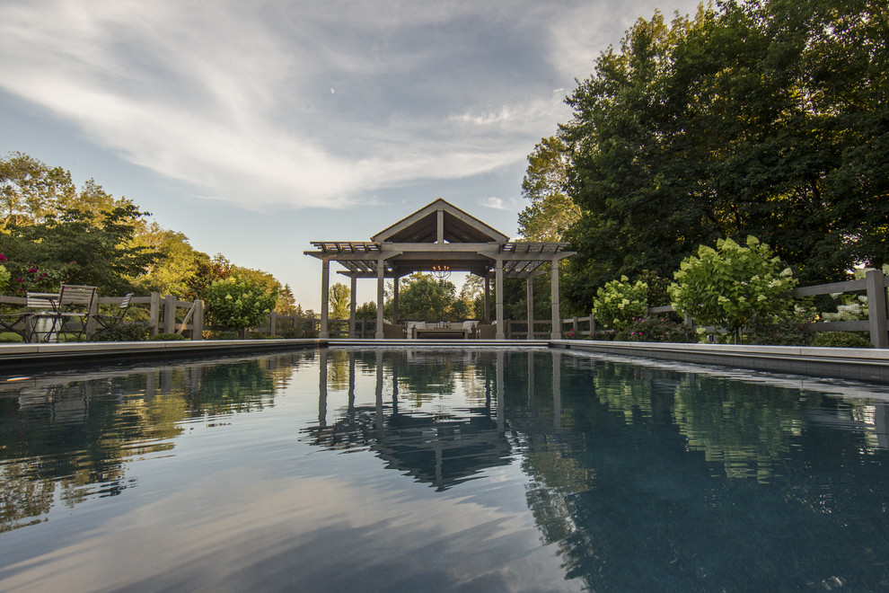 Idee per una piscina monocorsia tradizionale rettangolare di medie dimensioni e dietro casa con pavimentazioni in pietra naturale