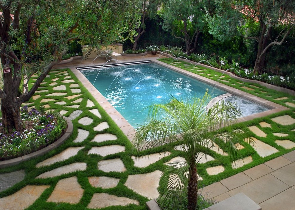Пример оригинального дизайна: бассейн в средиземноморском стиле с покрытием из каменной брусчатки и фонтаном
