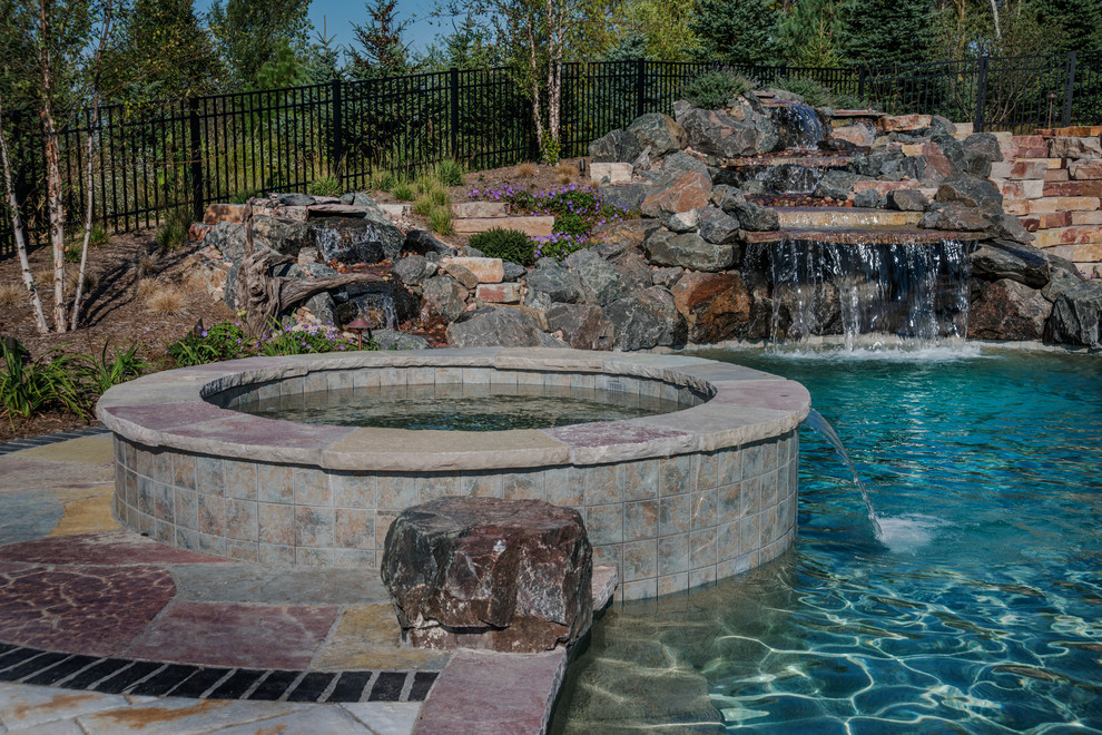 Cette photo montre une piscine naturelle et arrière montagne de taille moyenne et sur mesure avec un bain bouillonnant et des pavés en béton.