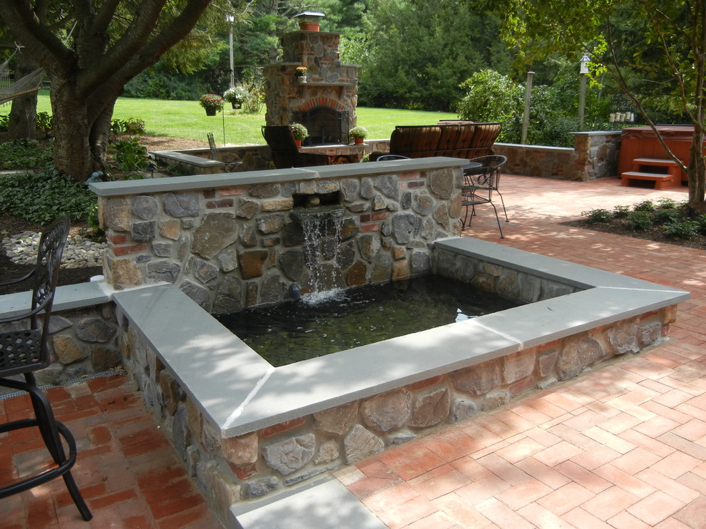 Esempio di una piccola piscina naturale rustica rettangolare in cortile con fontane e pavimentazioni in mattoni