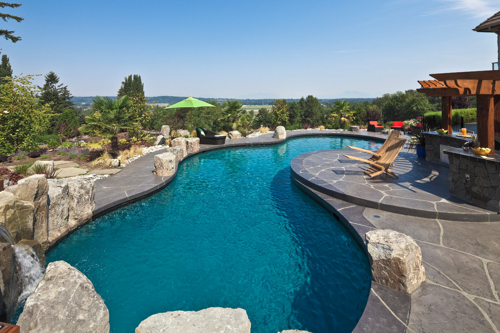 Esempio di una piscina chic personalizzata con pavimentazioni in pietra naturale