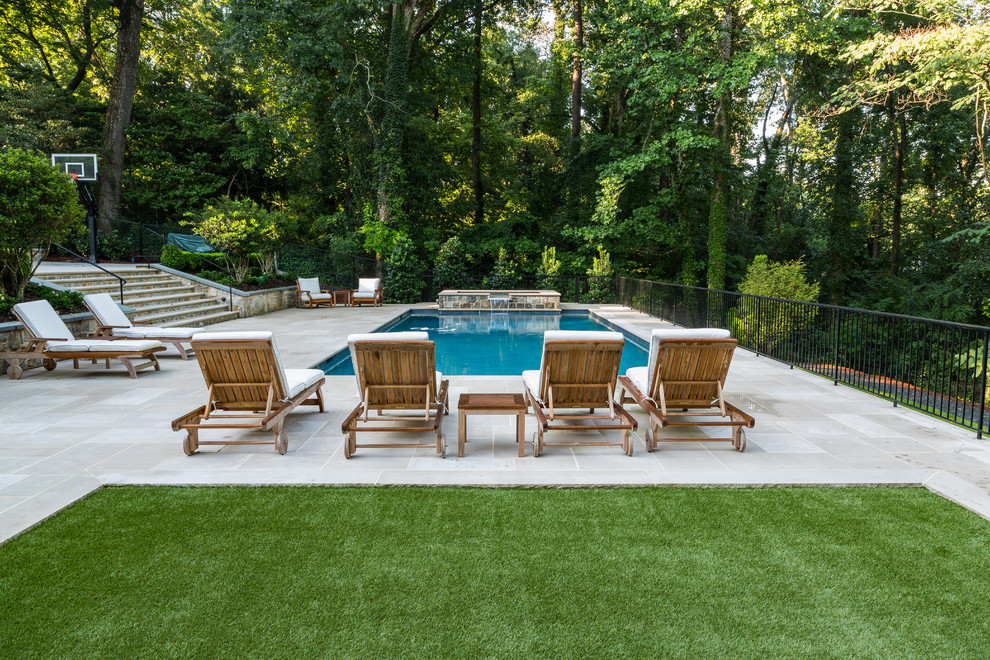 Идея дизайна: большой прямоугольный бассейн на заднем дворе в классическом стиле с покрытием из бетонных плит и забором
