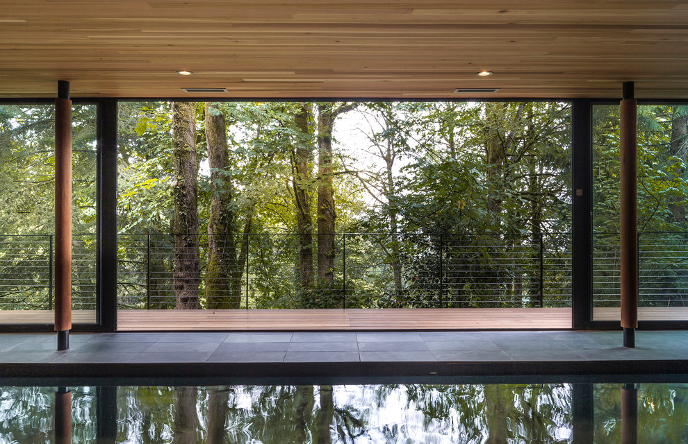 Ejemplo de piscina contemporánea rectangular y interior con adoquines de piedra natural