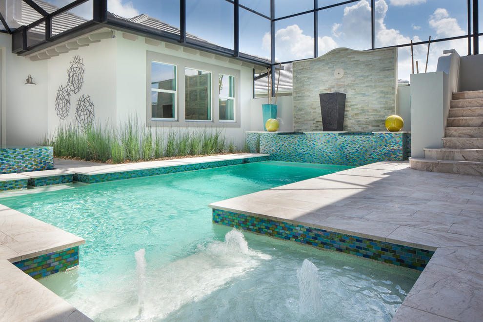 Diseño de piscina con fuente alargada exótica grande a medida en patio trasero con adoquines de piedra natural