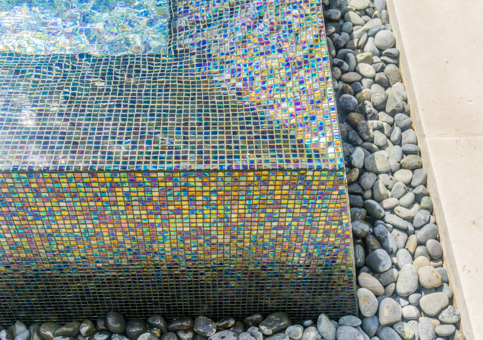 Foto di una grande piscina a sfioro infinito minimalista personalizzata in cortile con fontane e pedane