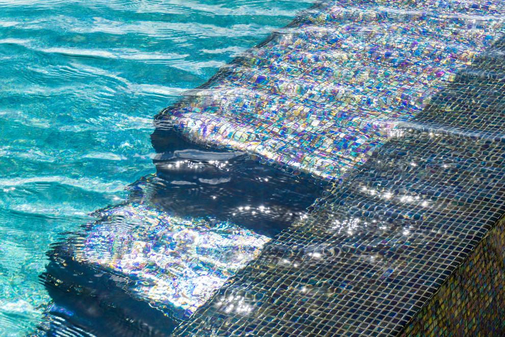 Imagen de piscina con fuente infinita minimalista grande a medida en patio con entablado