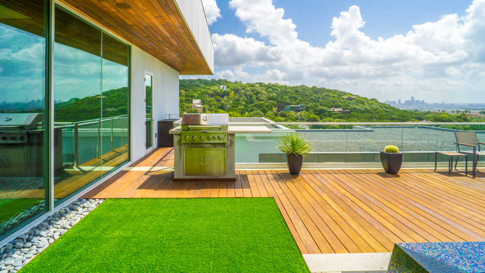 Example of a large minimalist courtyard custom-shaped infinity pool fountain design in Austin with decking