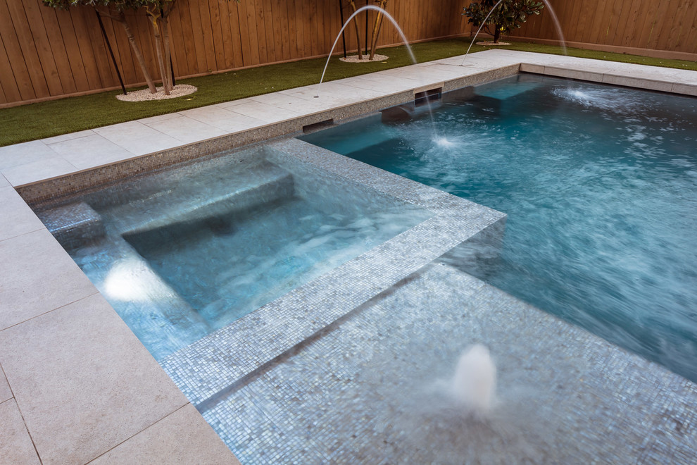 Esempio di una piccola piscina minimal rettangolare dietro casa con una vasca idromassaggio e piastrelle