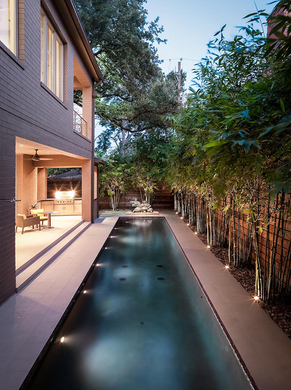 Esempio di una piscina monocorsia design rettangolare di medie dimensioni e dietro casa con pavimentazioni in cemento