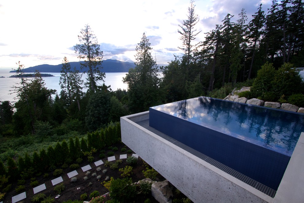 Inspiration for a mid-sized modern backyard concrete and rectangular infinity pool remodel in Vancouver