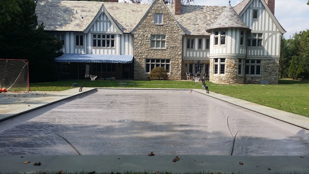 Large classic back rectangular lengths swimming pool in New York with natural stone paving.