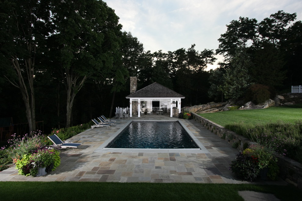 Пример оригинального дизайна: прямоугольный бассейн в классическом стиле с покрытием из каменной брусчатки и домиком у бассейна