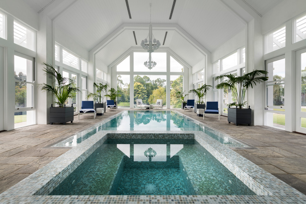 На фото: прямоугольный бассейн в доме в стиле неоклассика (современная классика) с джакузи и покрытием из плитки