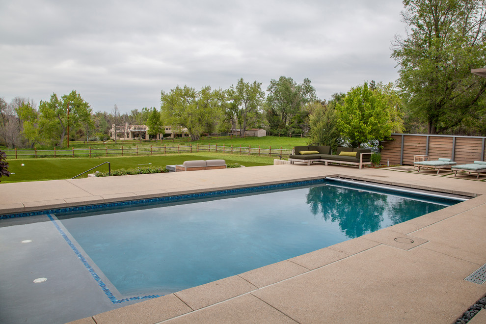На фото: большой прямоугольный, спортивный бассейн на заднем дворе в стиле модернизм с мощением тротуарной плиткой