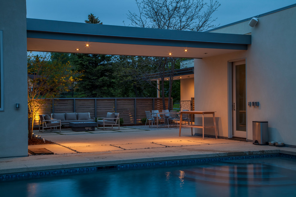 Idee per una grande piscina monocorsia moderna rettangolare dietro casa con pavimentazioni in cemento