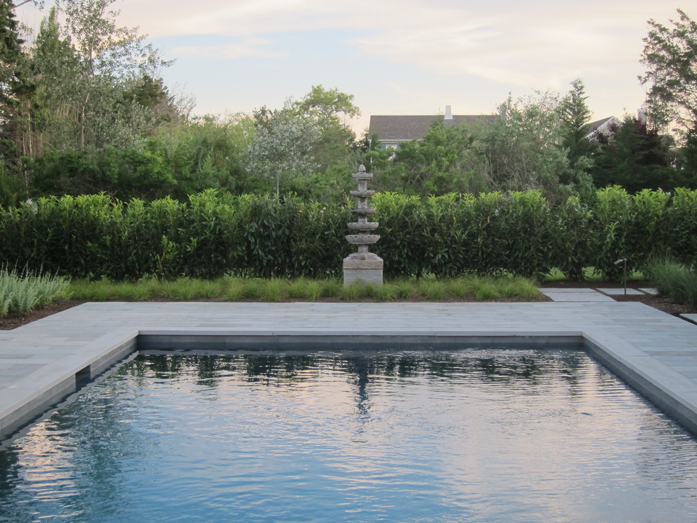 Пример оригинального дизайна: прямоугольный бассейн среднего размера на заднем дворе в современном стиле с фонтаном и покрытием из каменной брусчатки