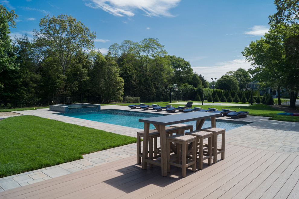 Photo of a coastal back rectangular lengths hot tub in New York with natural stone paving.