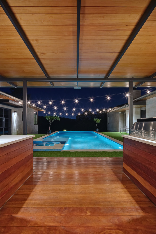 Inspiration for a contemporary courtyard rectangular infinity hot tub in Austin with decking.