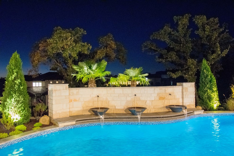 Modelo de piscina con fuente contemporánea de tamaño medio a medida en patio trasero con adoquines de piedra natural