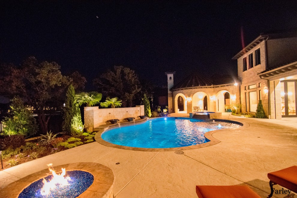 Imagen de piscina con fuente contemporánea de tamaño medio a medida en patio trasero con adoquines de piedra natural