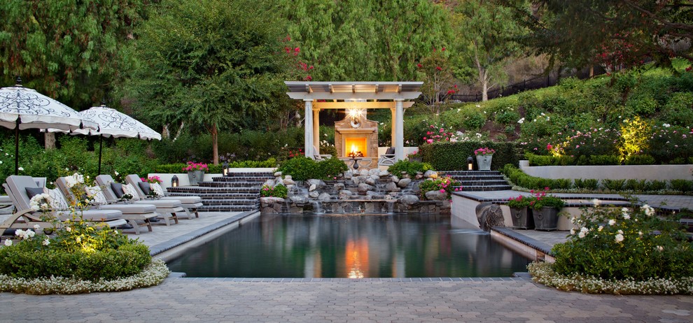 Пример оригинального дизайна: большой прямоугольный, спортивный бассейн на заднем дворе в классическом стиле с фонтаном