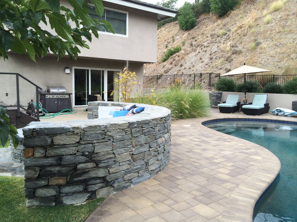 Modelo de piscina rural grande a medida en patio trasero con adoquines de piedra natural