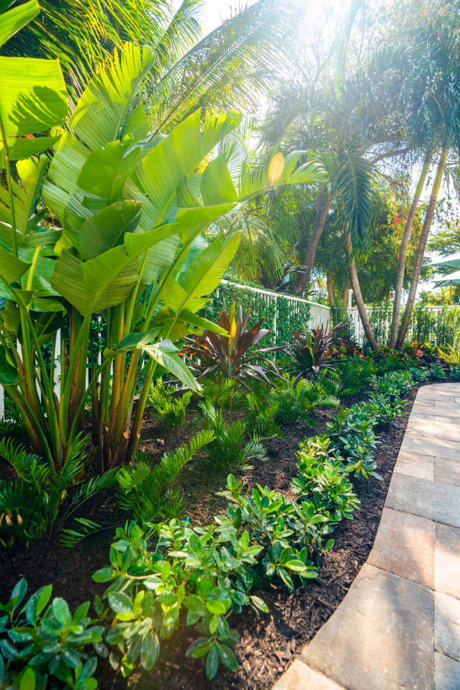 Ispirazione per un grande giardino tropicale in cortile con pavimentazioni in cemento