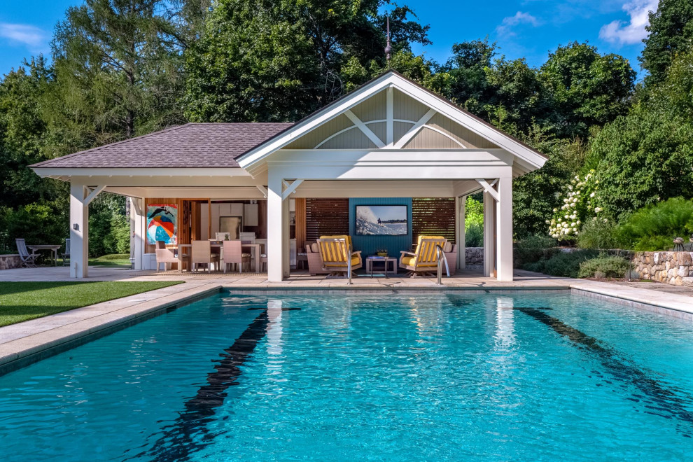 Modelo de casa de la piscina y piscina alargada tradicional renovada grande rectangular en patio trasero con adoquines de piedra natural