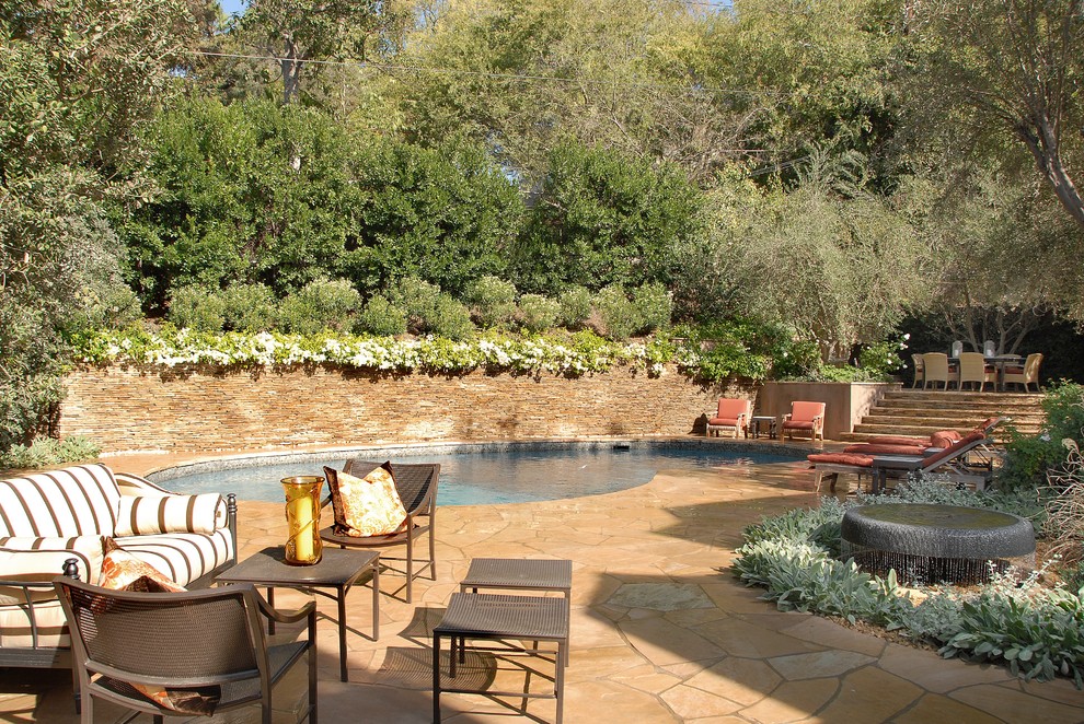 Foto de piscina mediterránea de tamaño medio a medida en patio trasero con adoquines de piedra natural