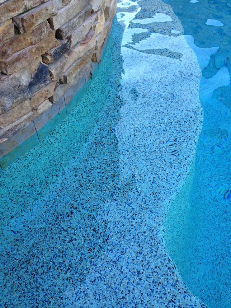 Réalisation d'une piscine naturelle et arrière tradition de taille moyenne et sur mesure avec des pavés en pierre naturelle.