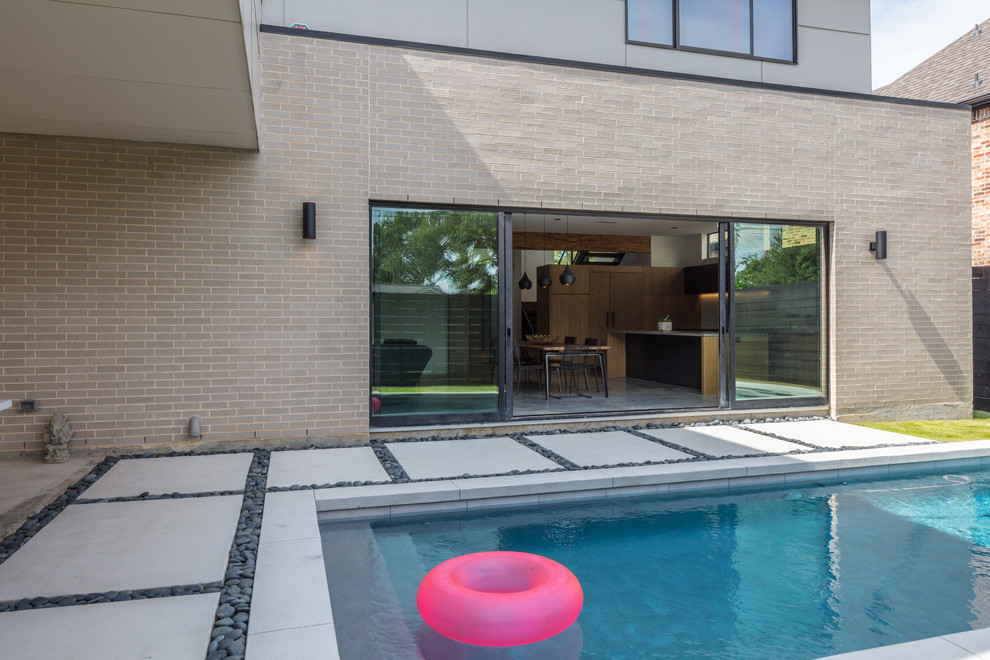 На фото: прямоугольный бассейн среднего размера на внутреннем дворе в стиле модернизм с мощением тротуарной плиткой с