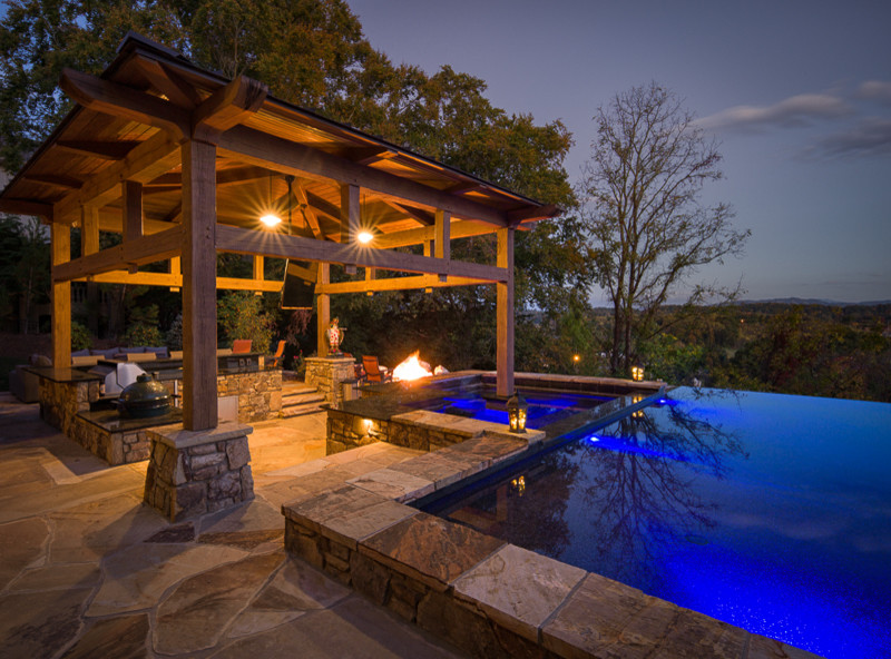 Pool house - large rustic backyard stone and rectangular infinity pool house idea in Charlotte