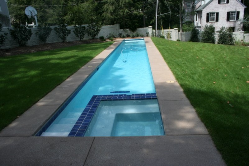 Example of a mid-sized classic backyard concrete and custom-shaped lap pool design in Raleigh