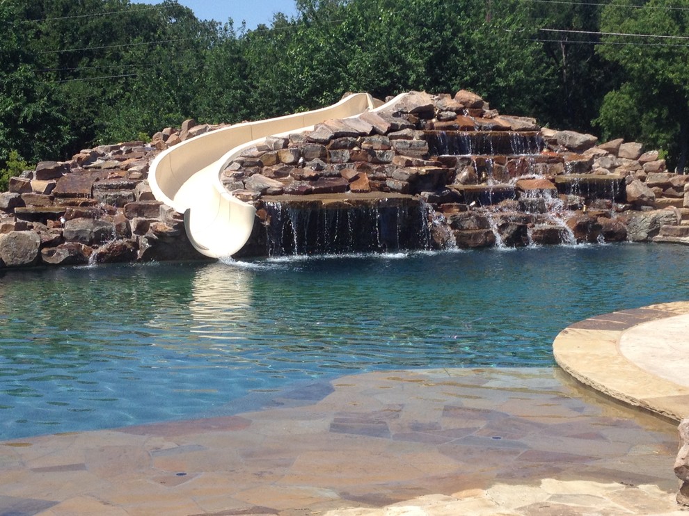 Water slide - huge coastal backyard stamped concrete and custom-shaped lap water slide idea in Dallas