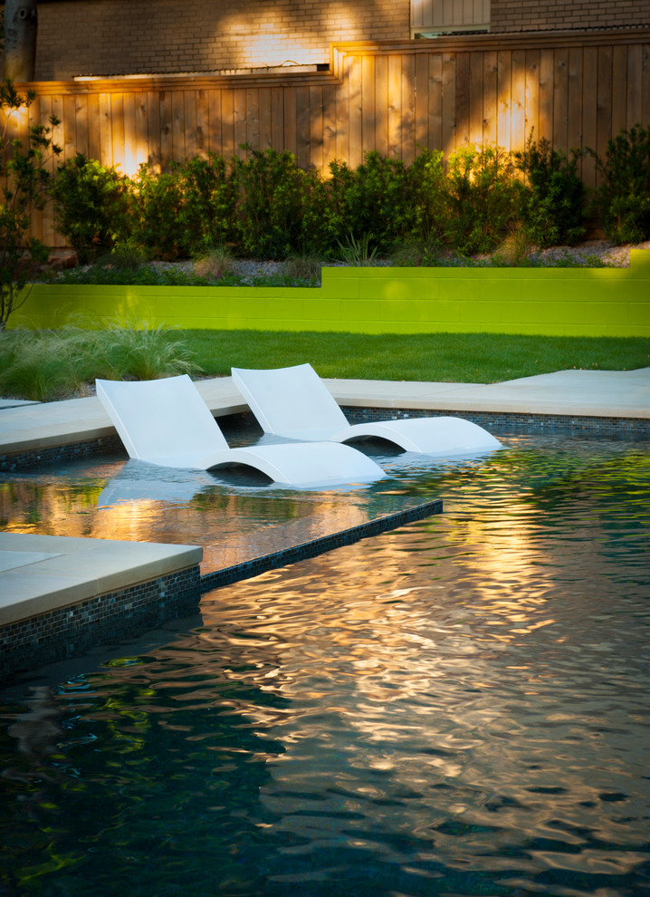 Immagine di una piscina minimalista a "L" di medie dimensioni e dietro casa con lastre di cemento