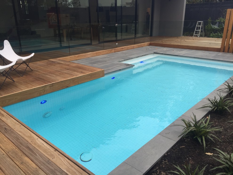 Mittelgroßes Modernes Sportbecken hinter dem Haus in individueller Form mit Natursteinplatten in Melbourne