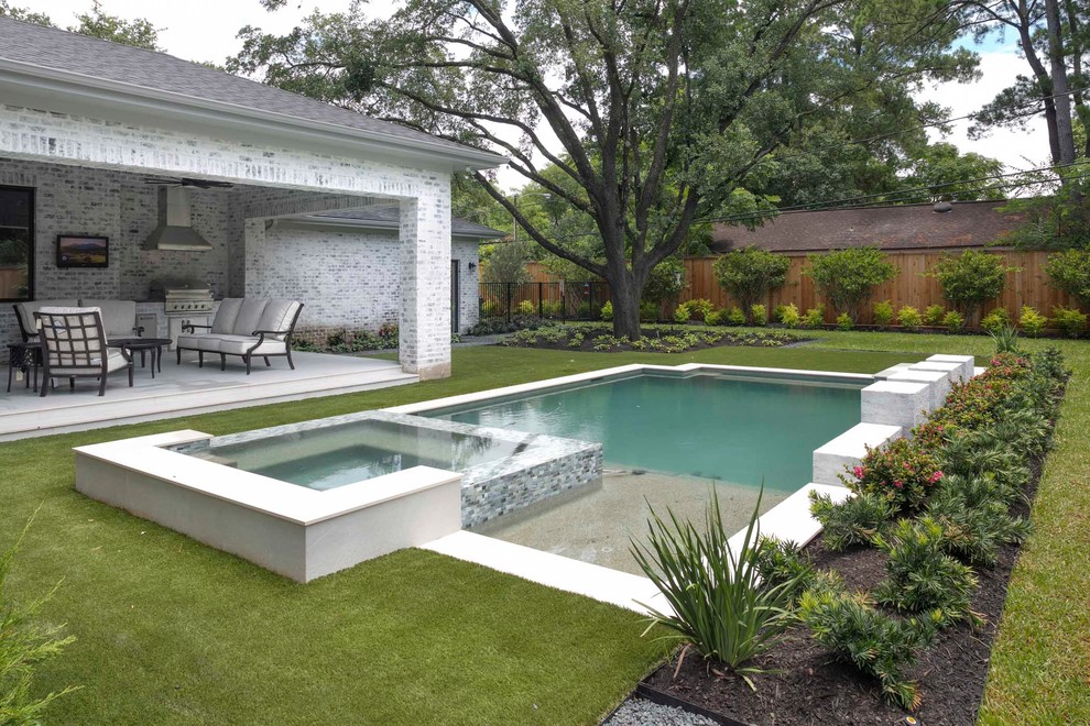 This is an example of a large country back rectangular infinity swimming pool in Houston with a water feature.