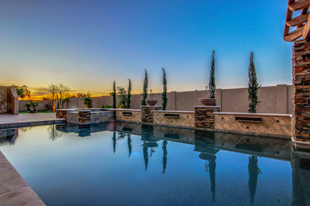 Imagen de piscina con fuente alargada mediterránea grande rectangular en patio trasero con adoquines de piedra natural
