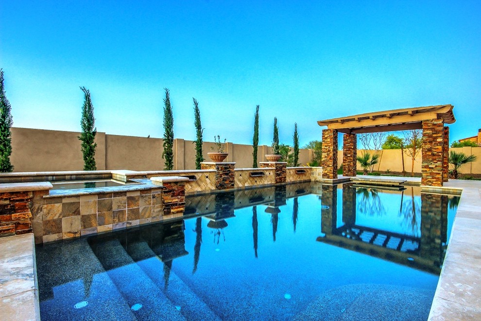 На фото: большой прямоугольный, спортивный бассейн на заднем дворе в средиземноморском стиле с фонтаном и покрытием из каменной брусчатки с
