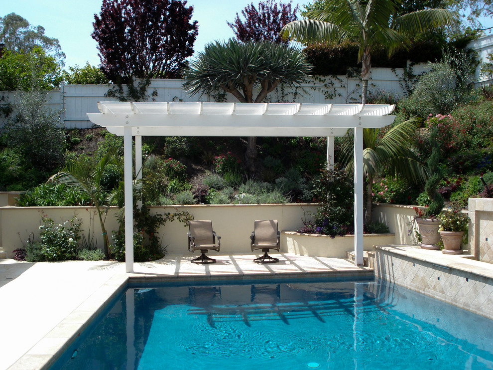 Пример оригинального дизайна: спортивный, угловой бассейн среднего размера на заднем дворе в стиле шебби-шик с фонтаном и покрытием из плитки