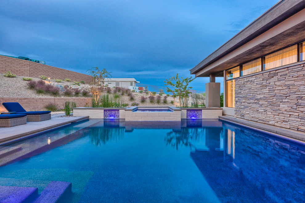 Modelo de piscinas y jacuzzis alargados modernos grandes a medida en patio trasero con adoquines de hormigón