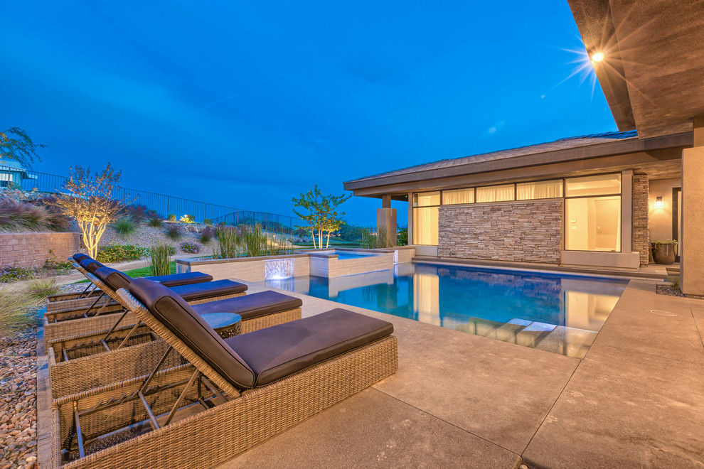 Modelo de piscinas y jacuzzis alargados minimalistas grandes a medida en patio trasero con adoquines de hormigón