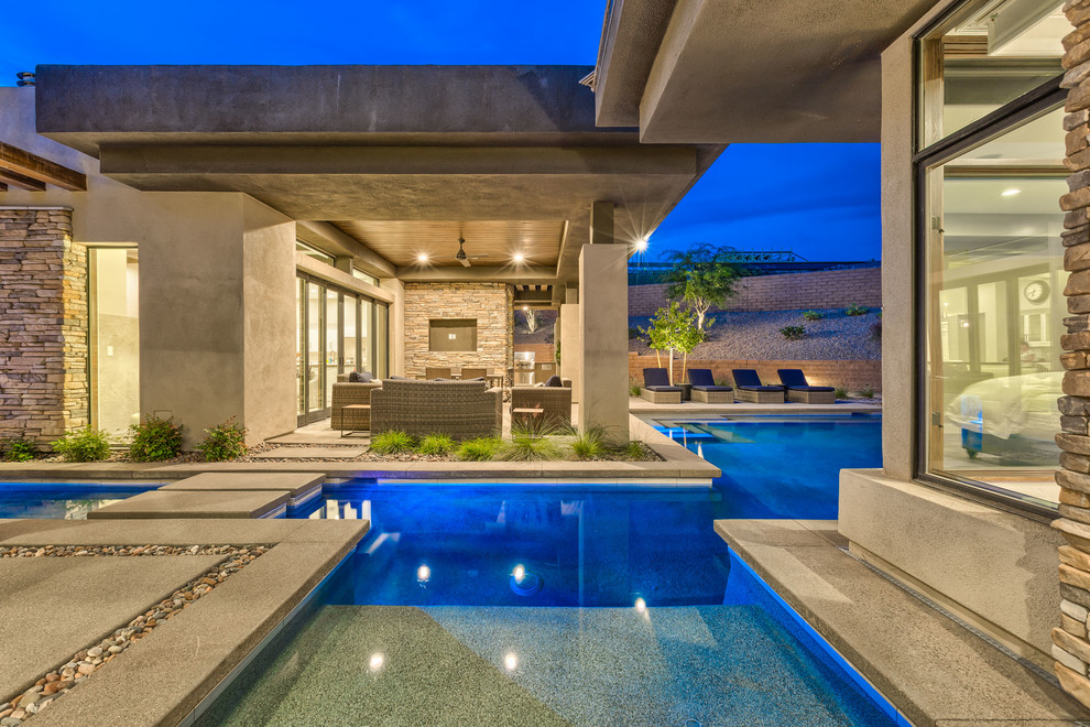 Idee per una grande piscina monocorsia moderna personalizzata dietro casa con una vasca idromassaggio e pavimentazioni in cemento