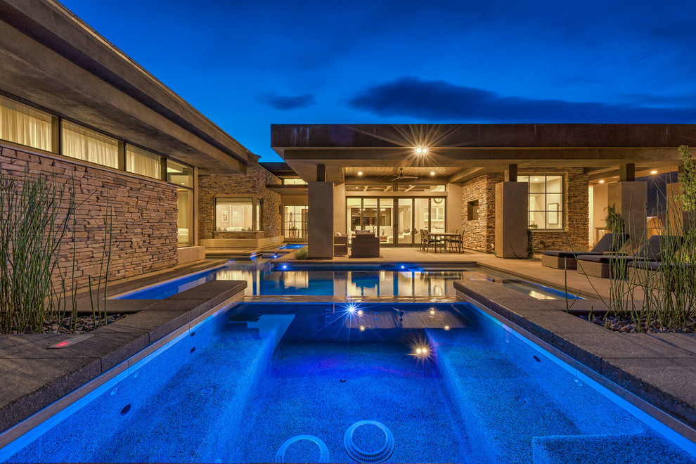 Idee per una grande piscina monocorsia minimalista personalizzata dietro casa con una vasca idromassaggio e pavimentazioni in cemento