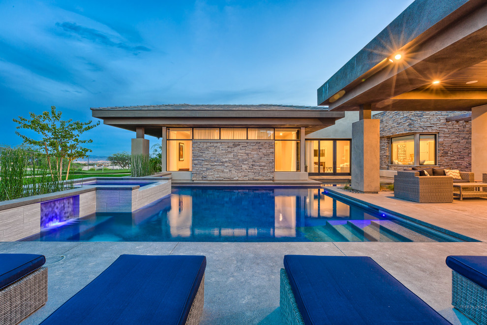 Idee per una grande piscina monocorsia minimalista personalizzata dietro casa con una vasca idromassaggio e pavimentazioni in cemento