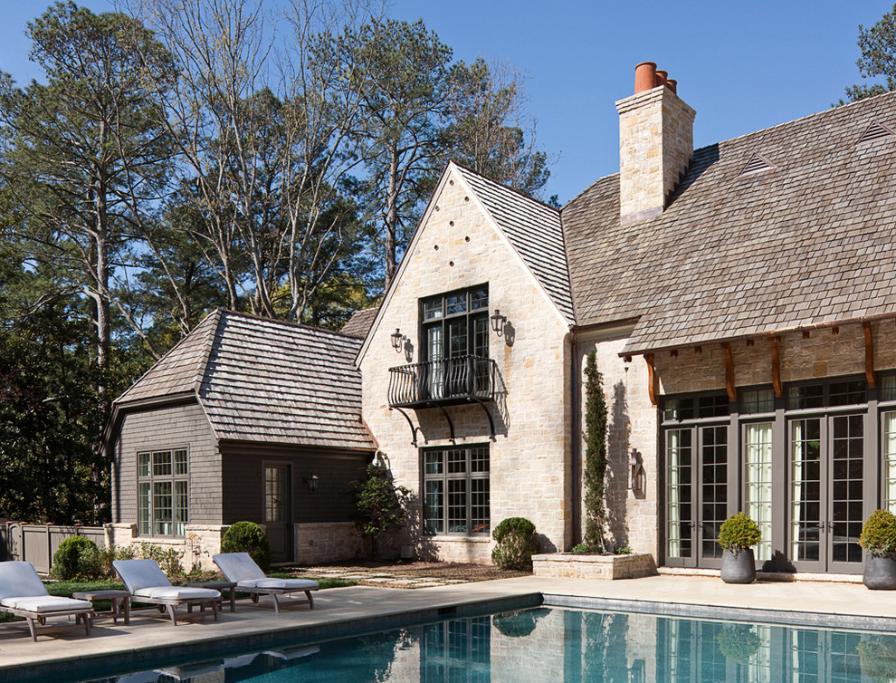 Immagine di una grande piscina monocorsia classica rettangolare dietro casa con una vasca idromassaggio e pavimentazioni in pietra naturale