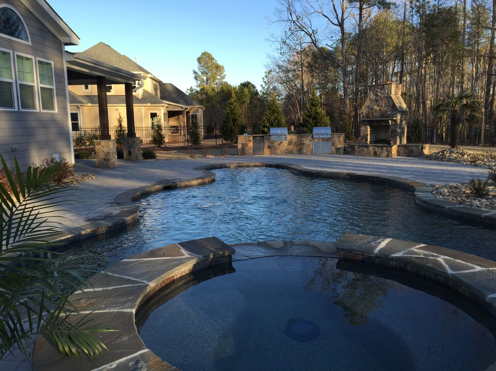 Imagen de piscinas y jacuzzis naturales de estilo americano extra grandes a medida en patio trasero con adoquines de piedra natural