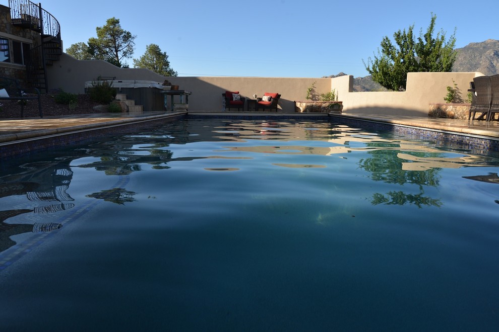 Immagine di una grande piscina monocorsia tradizionale rettangolare dietro casa con una vasca idromassaggio e piastrelle